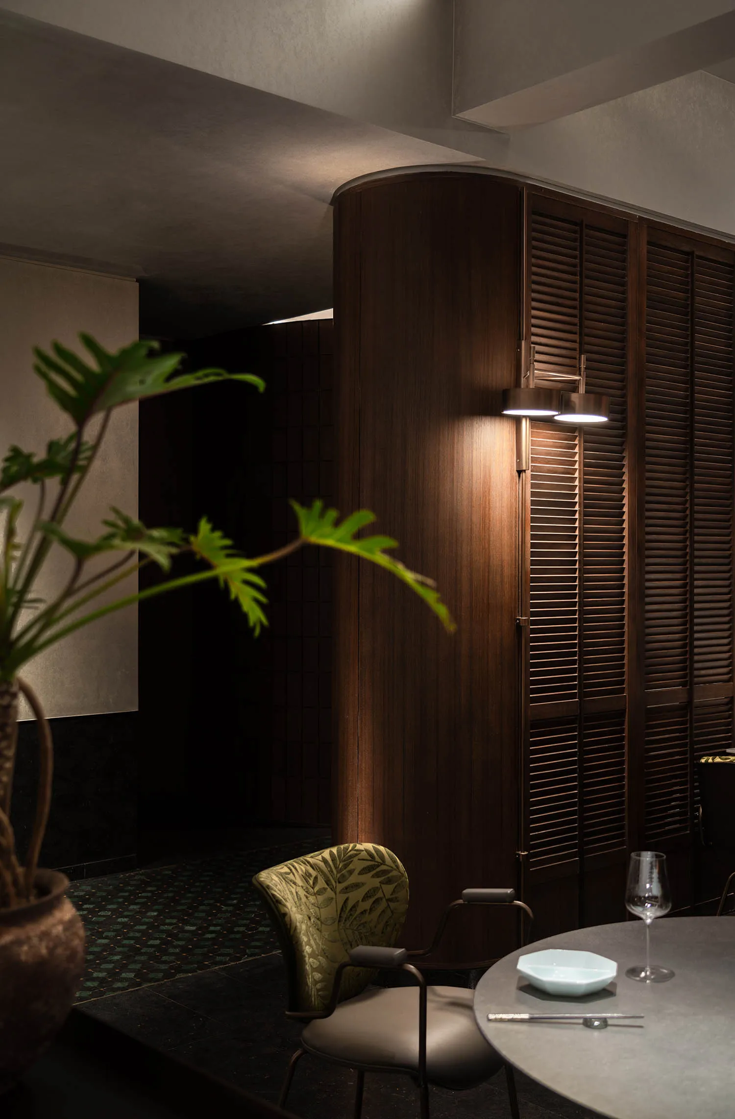 Modern restaurant interior featuring walnut paneling and industrial-style lighting.