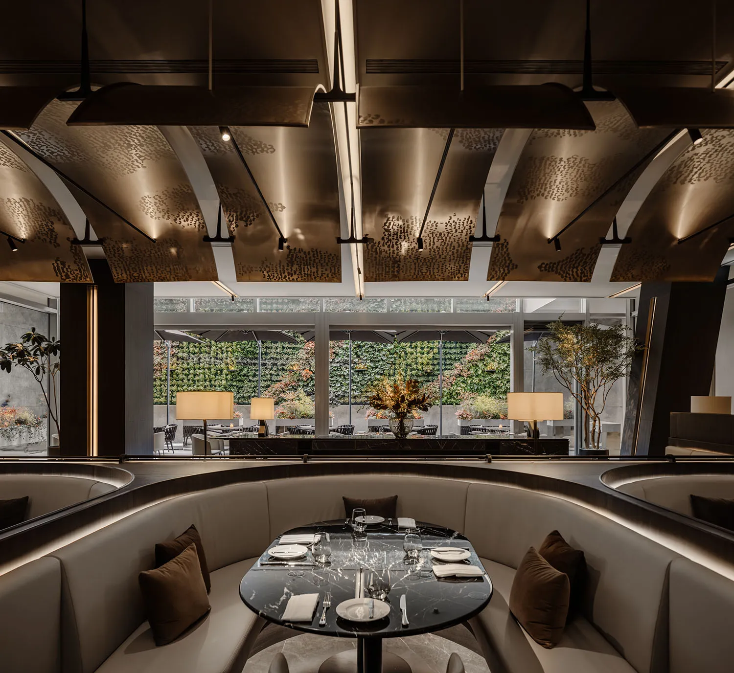 Modern restaurant interior with elegant marble table setting, leather seating, and contemporary lighting fixtures.