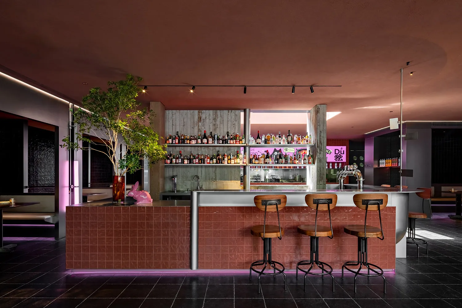 Industrial-style bar with brick counter and wooden stools.