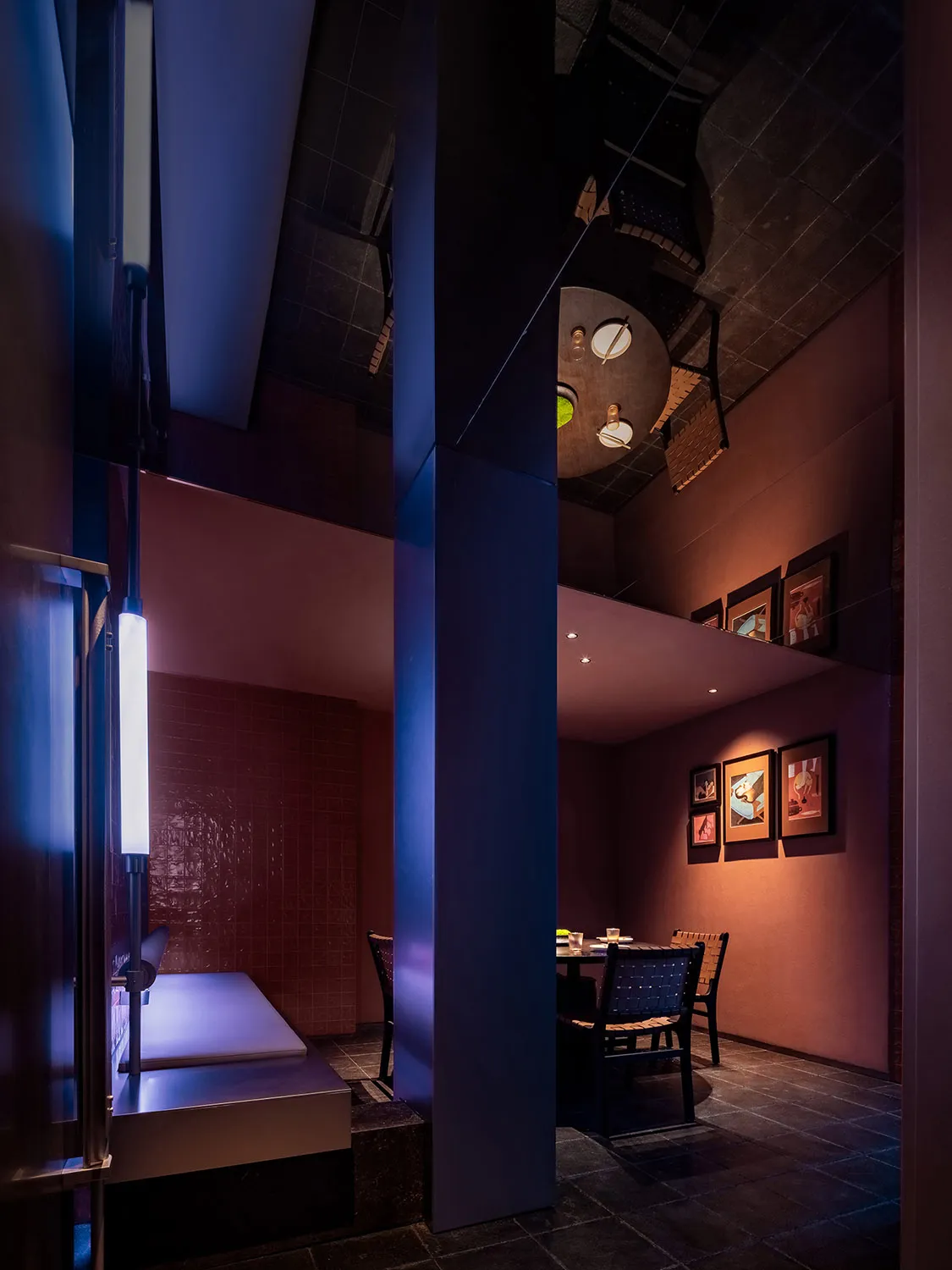 Modern minimalist restaurant interior with brick walls and warm lighting.