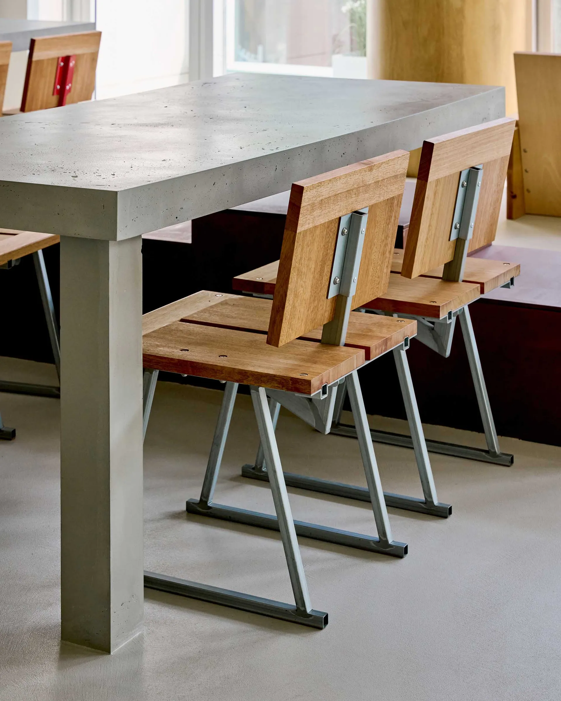 An industrial-style concrete table paired with wooden and metal chairs.