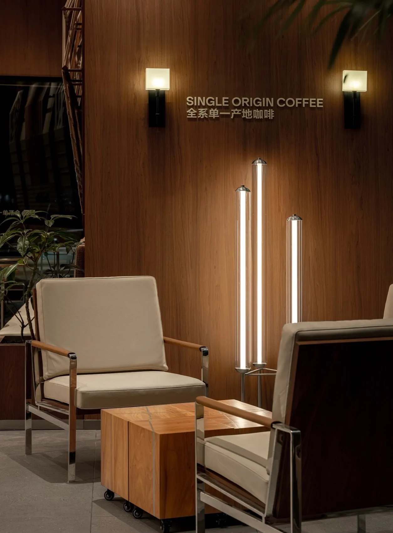 Modern coffee shop featuring wooden walls, leather seating, and single-origin coffee signage.