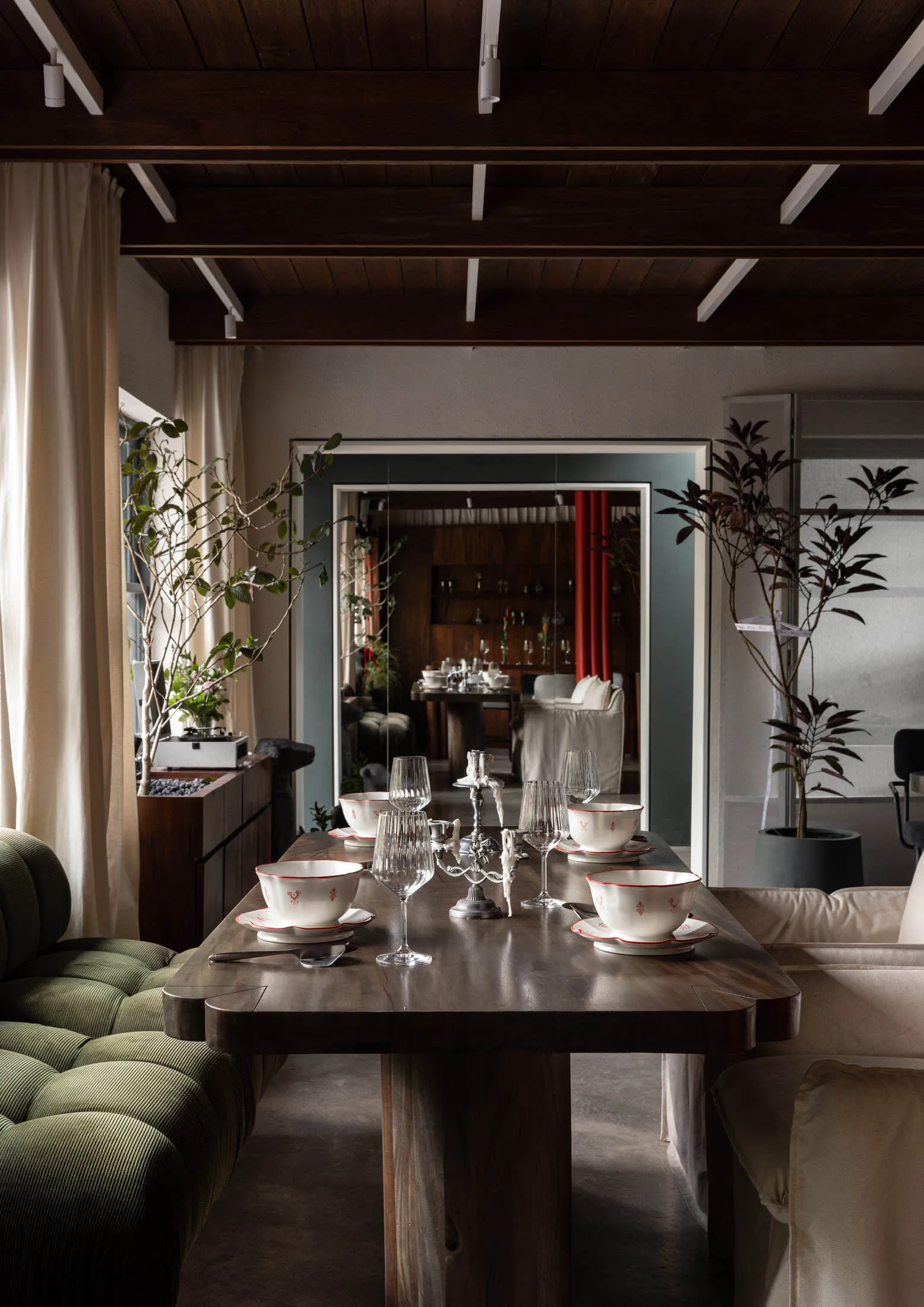 A modern dining room featuring a wooden table set for a meal.