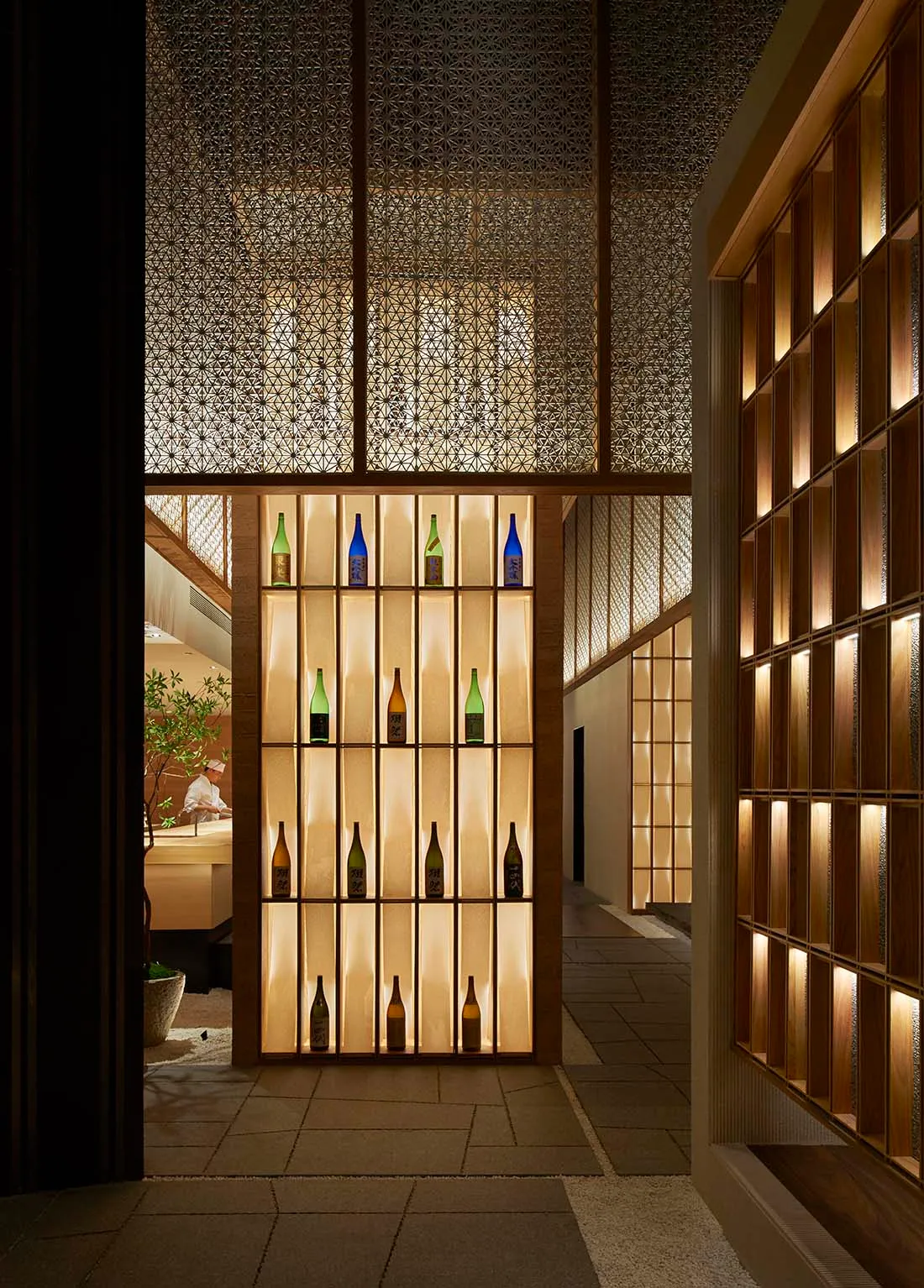 現代酒吧室內，發光層架展示酒瓶，搭配圖紋天花板。