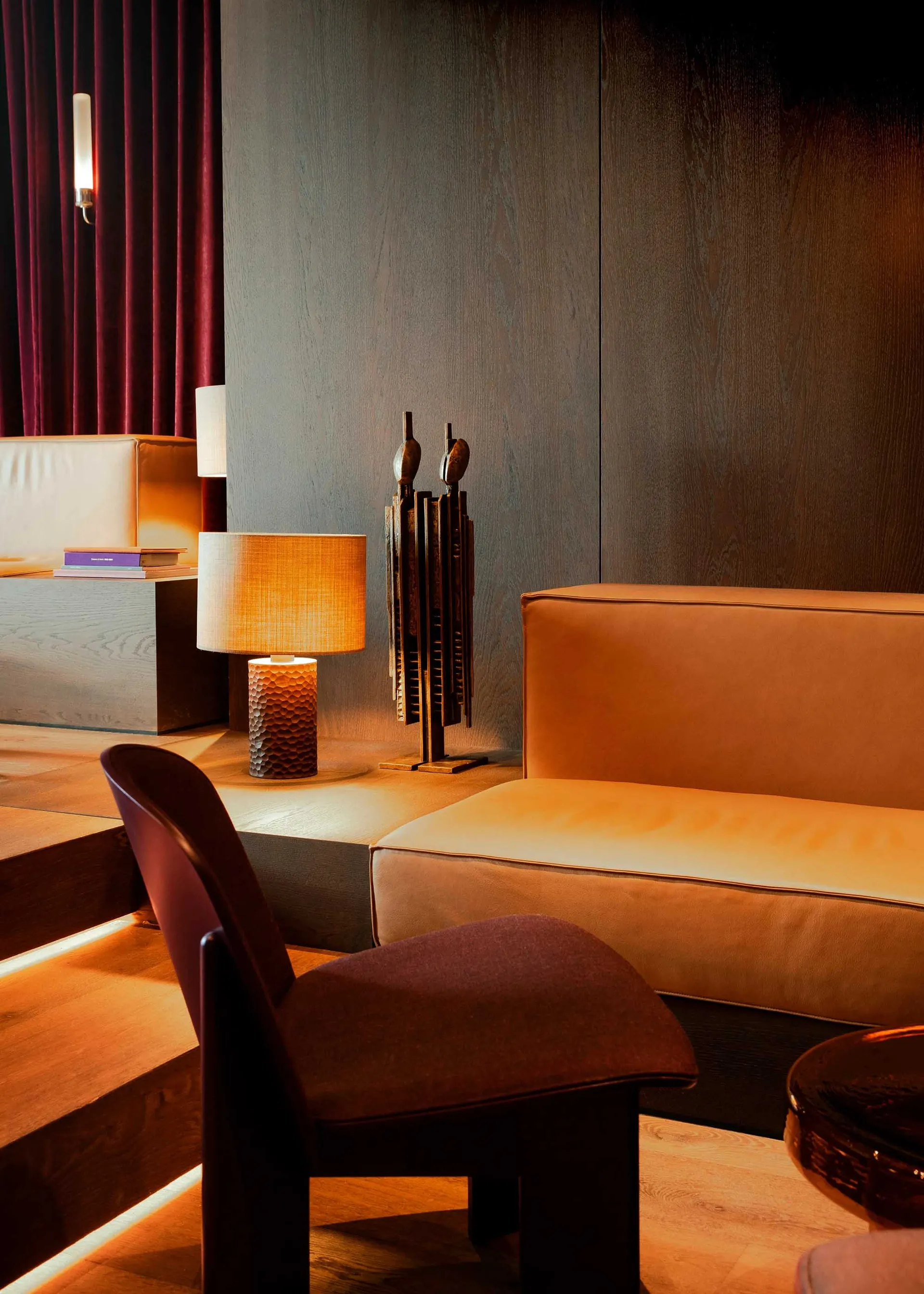 A modern living room featuring a leather sofa on a wooden floor.