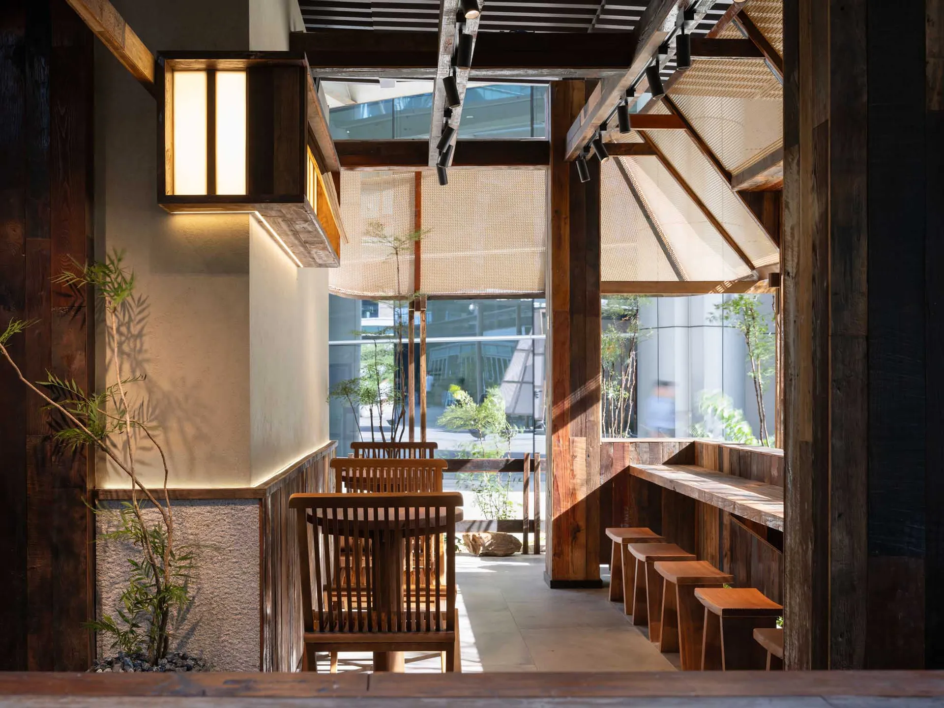 A modern restaurant interior featuring wooden furniture, natural lighting, and a warm, inviting atmosphere.