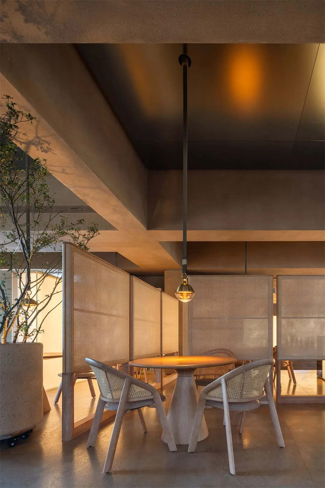 餐廳室內視圖,展示編織布料面板與混凝土牆面。