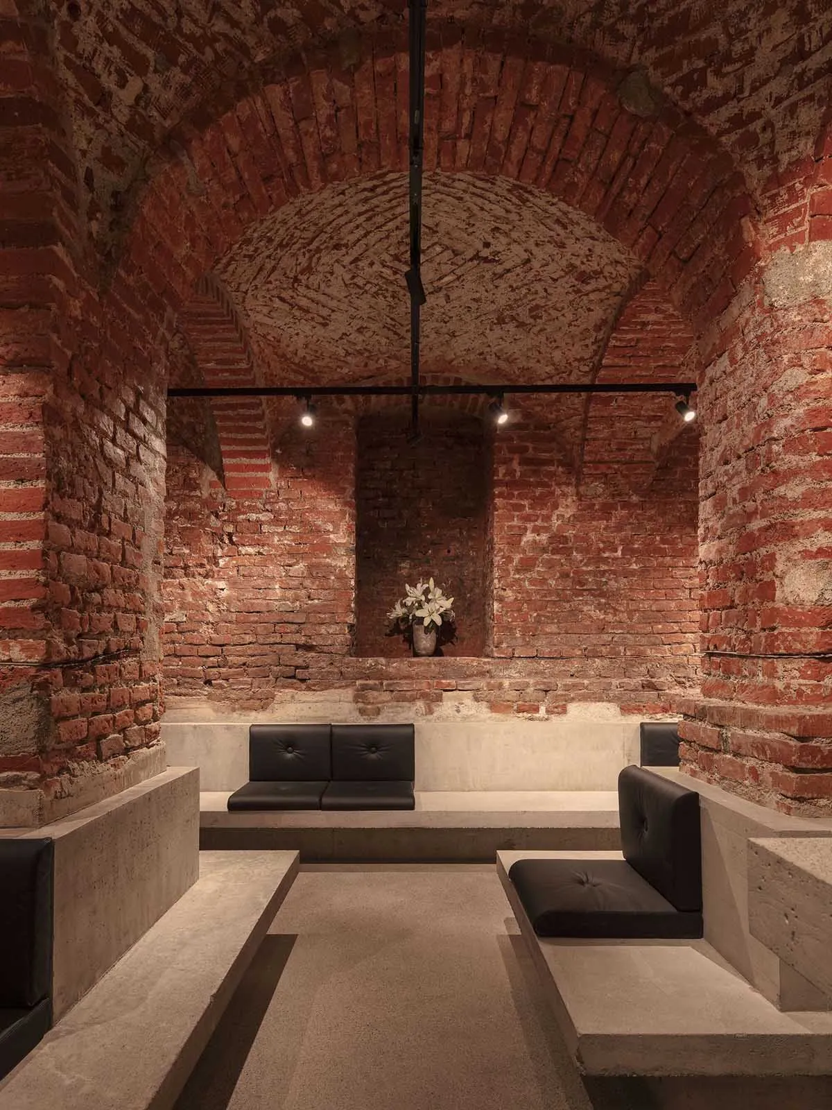 Indoor industrial-style cafe with brick walls and concrete seating.