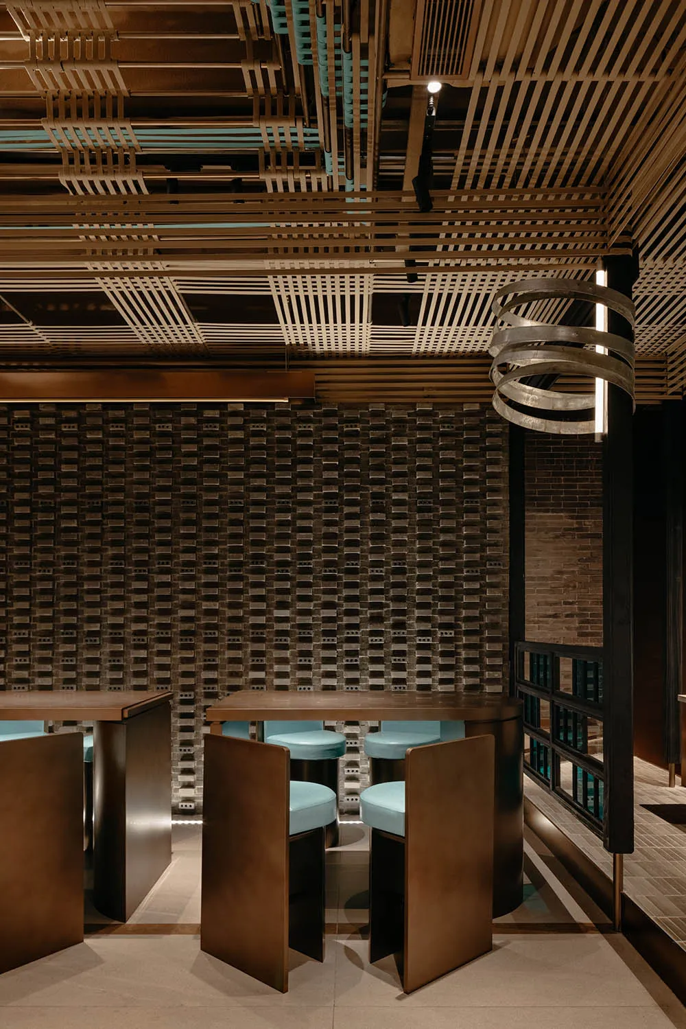 A minimalist restaurant interior featuring concrete walls and wooden furniture.