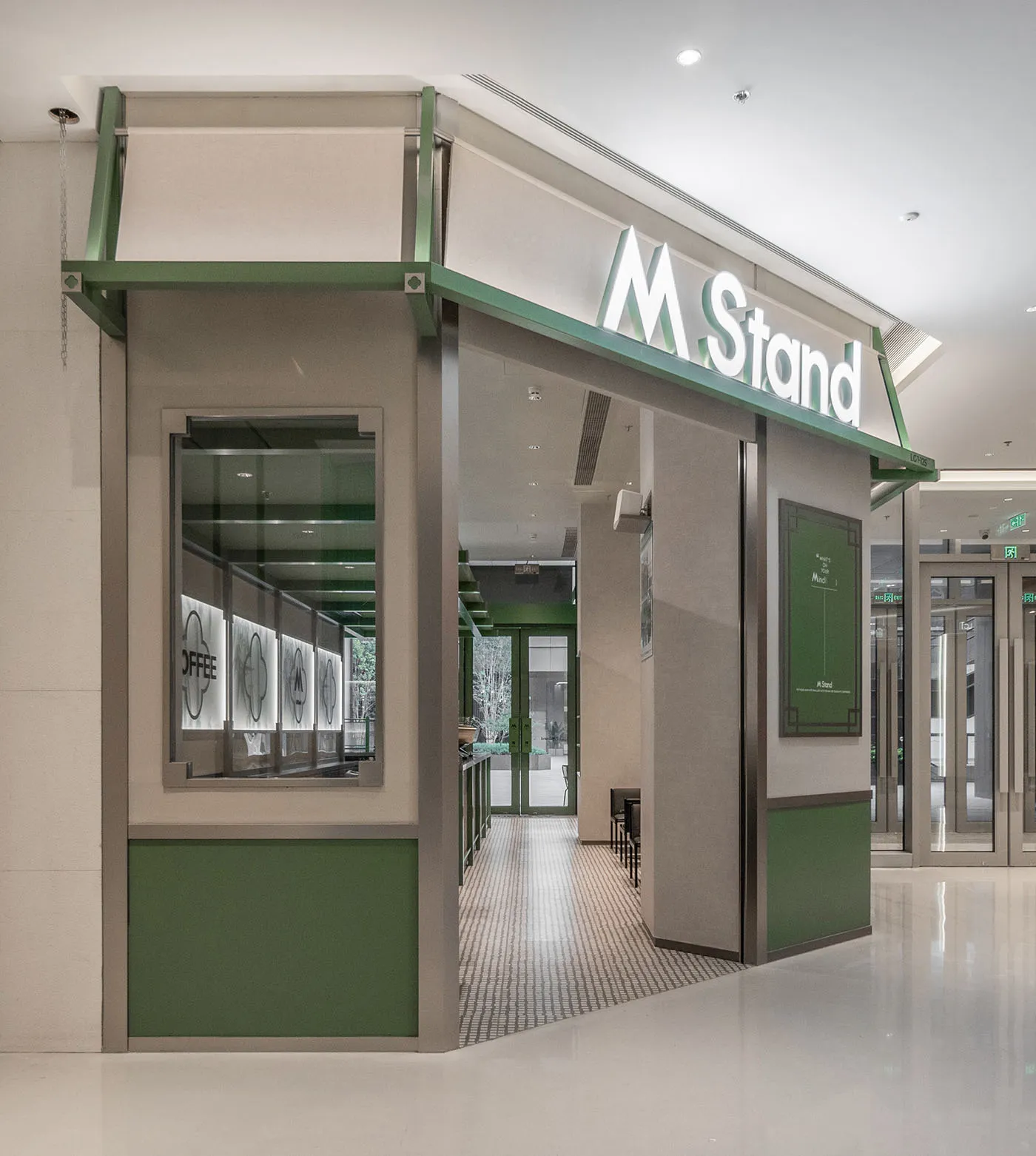 A modern coffee shop interior with a minimalist design and green accents.