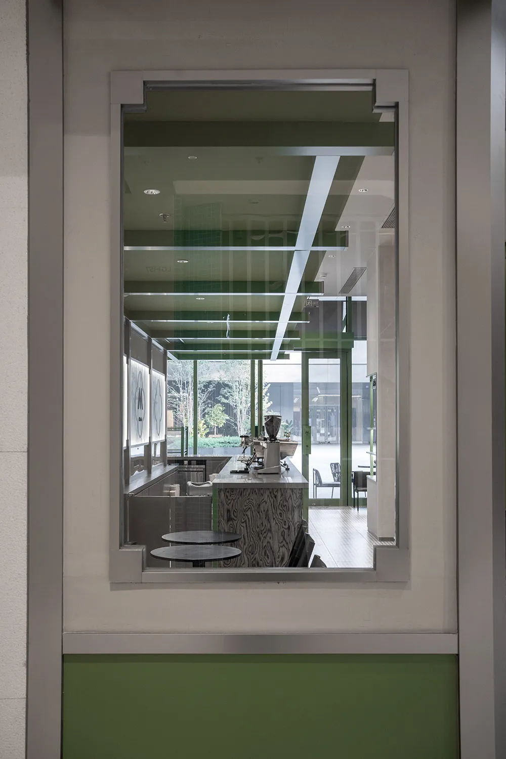 A modern coffee shop interior featuring a glass counter and sleek design elements.