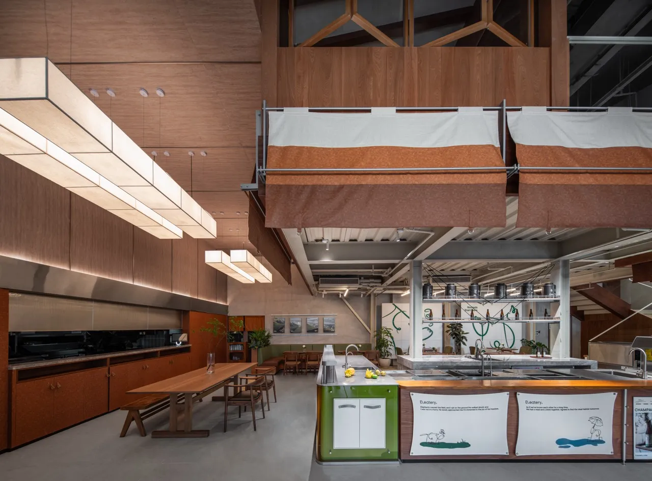 A modern commercial kitchen with wooden elements and a long table.