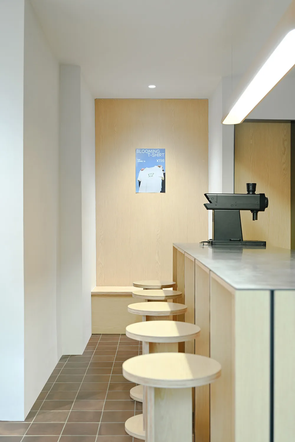 A modern coffee shop with industrial design elements and wooden stools.