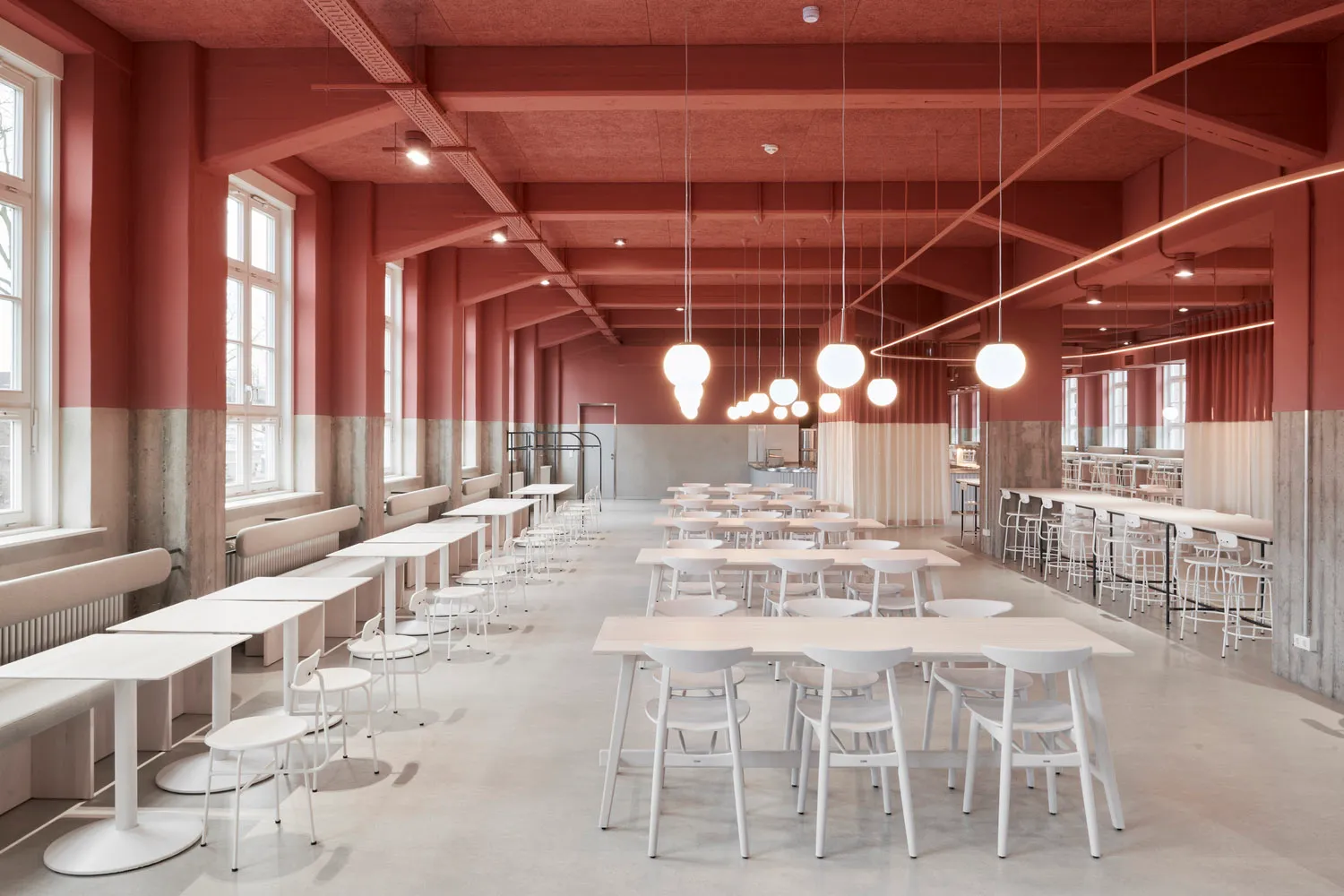 Large, spacious cafeteria with modern, light-colored furniture seating.