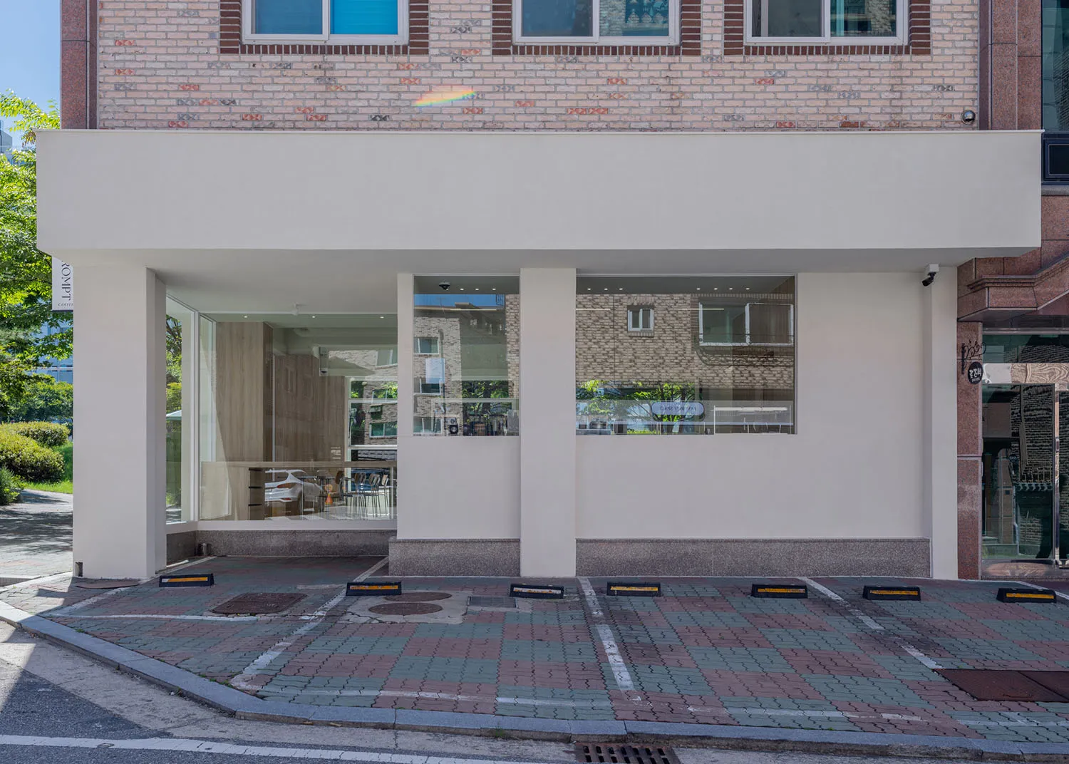 一座以玻璃與混凝土材質打造的現代咖啡店外觀。