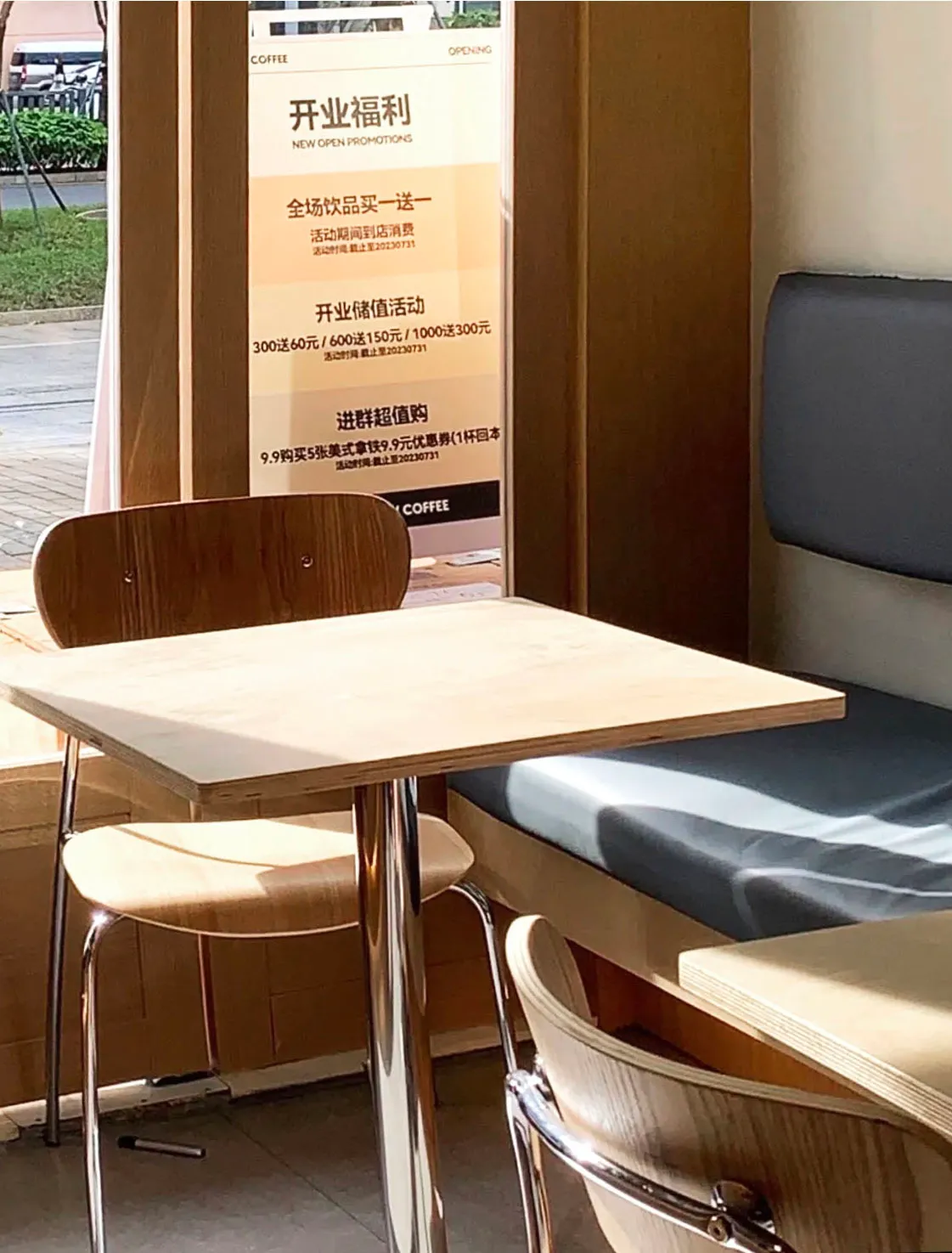 A cafe interior with wooden furniture and a promotional poster