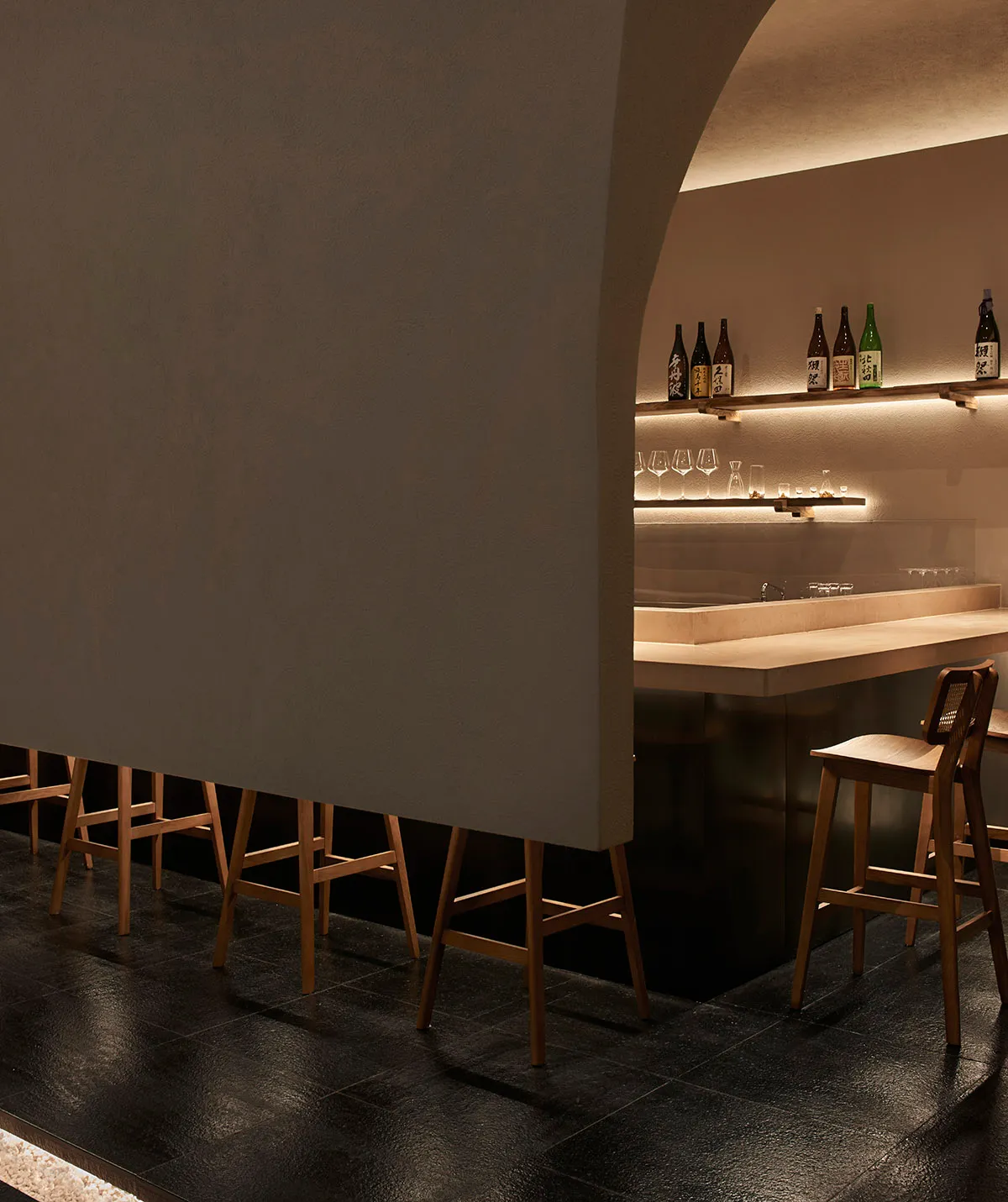 Industrial-style bar interior featuring wooden stools and leather seating.