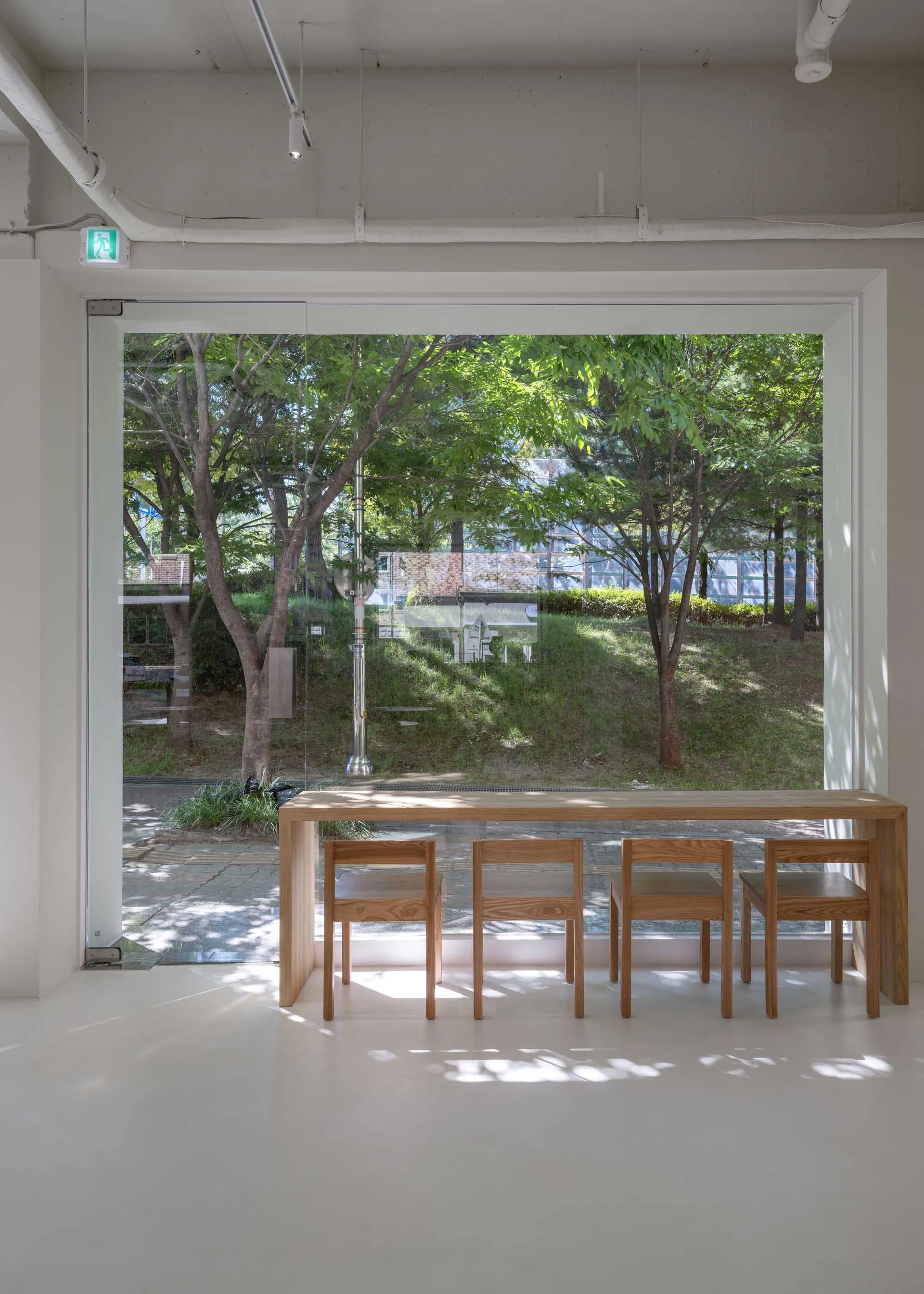 Minimalist interior design featuring wood furniture and large glass window.