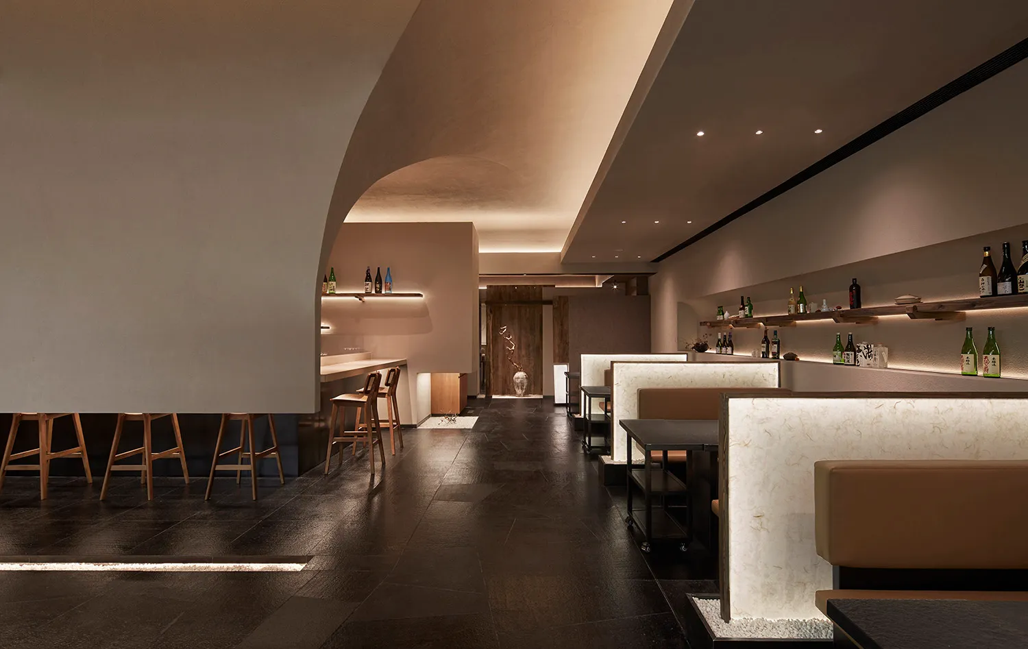 A minimalist restaurant interior with wooden tables and benches, white marble accents, and a warm, inviting atmosphere.