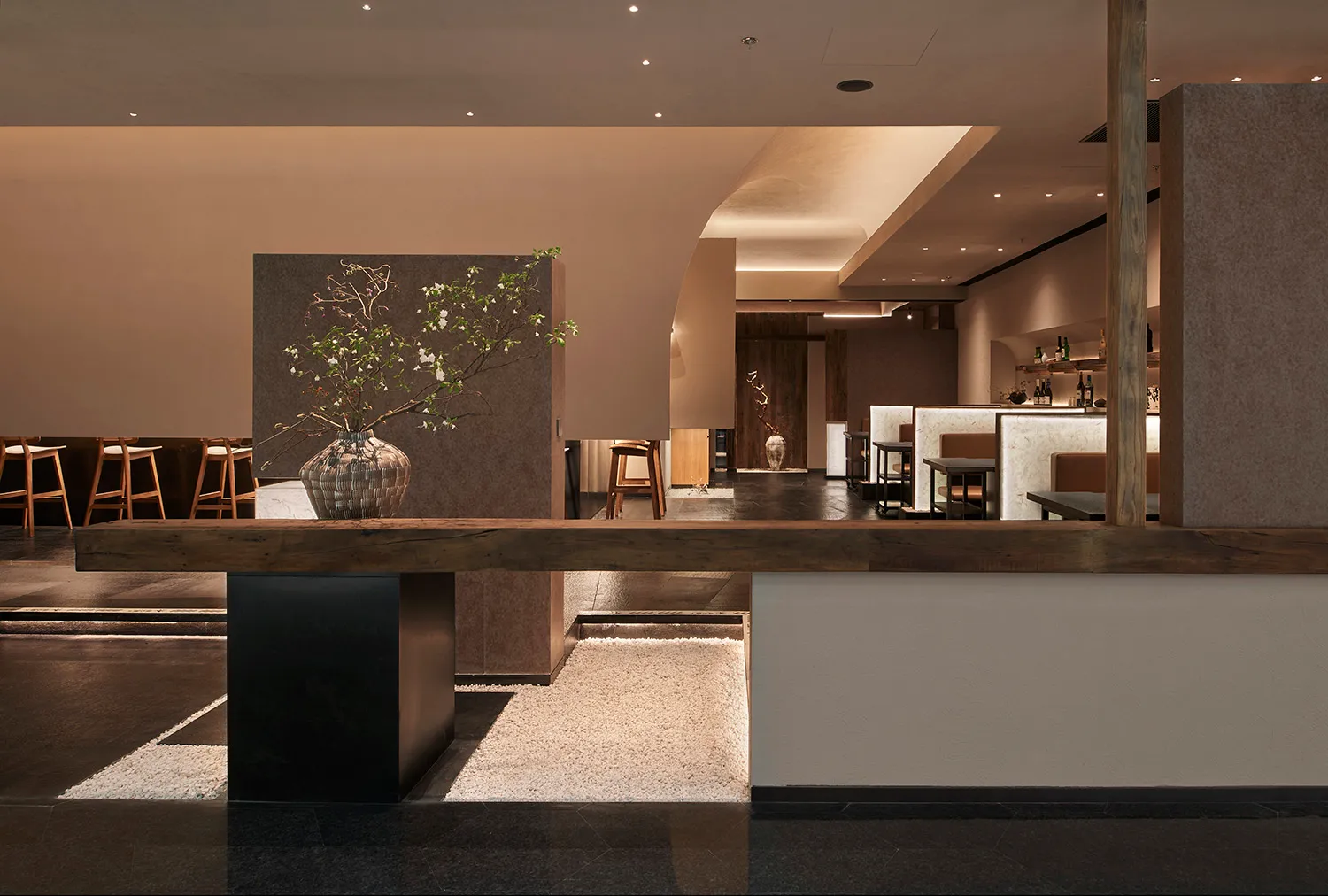 A modern restaurant interior with a wooden counter and seating area.