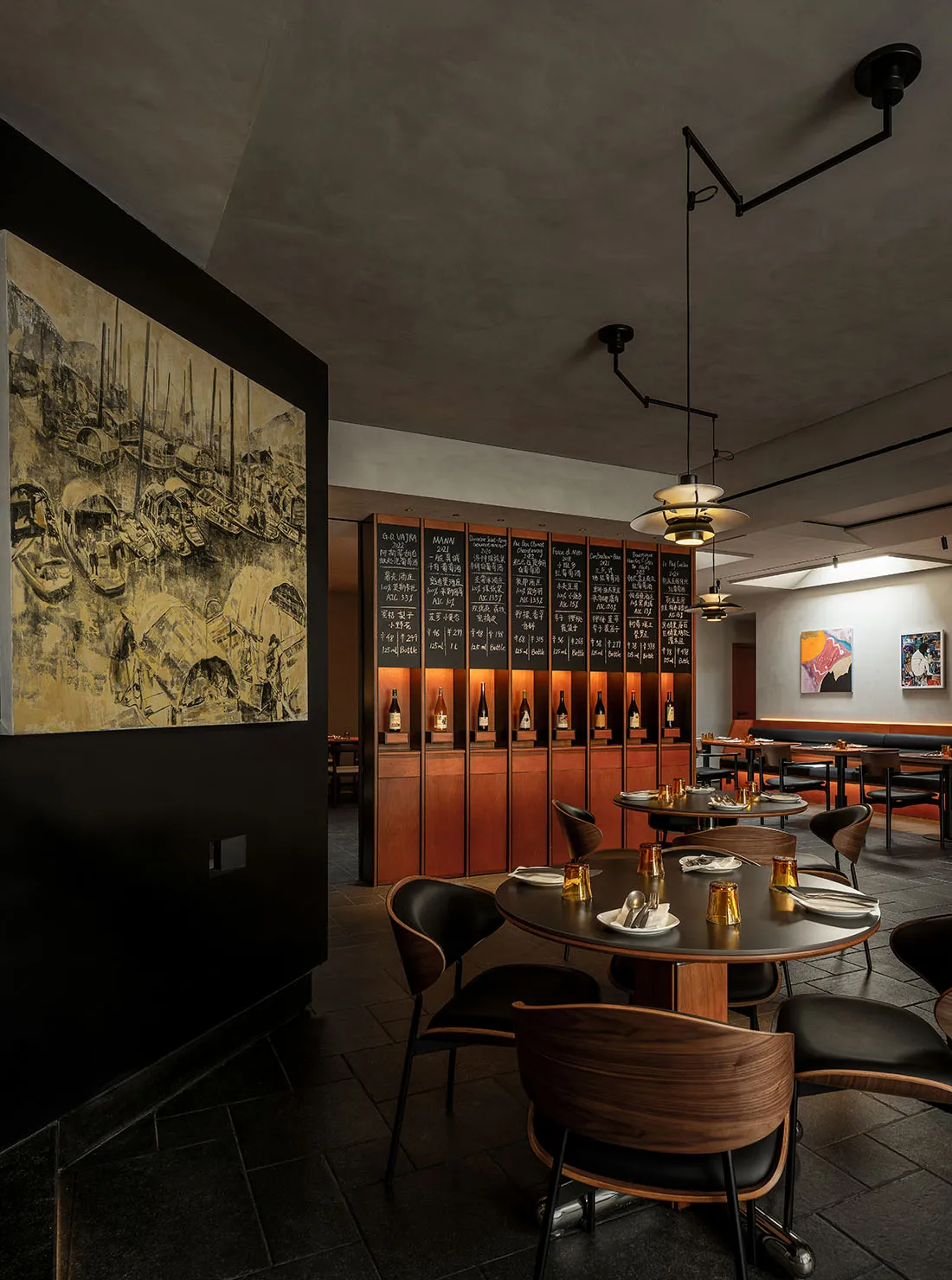 A modern restaurant interior with dark tones, wooden tables, and glass shelves.
