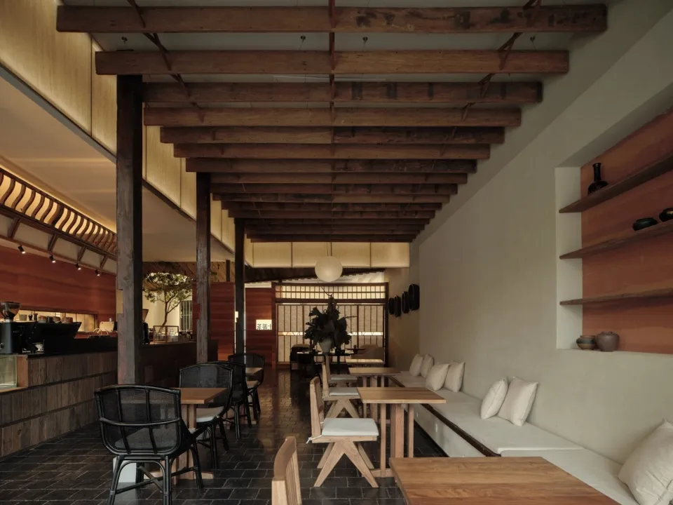 Modern restaurant interior with wood ceiling and seating area