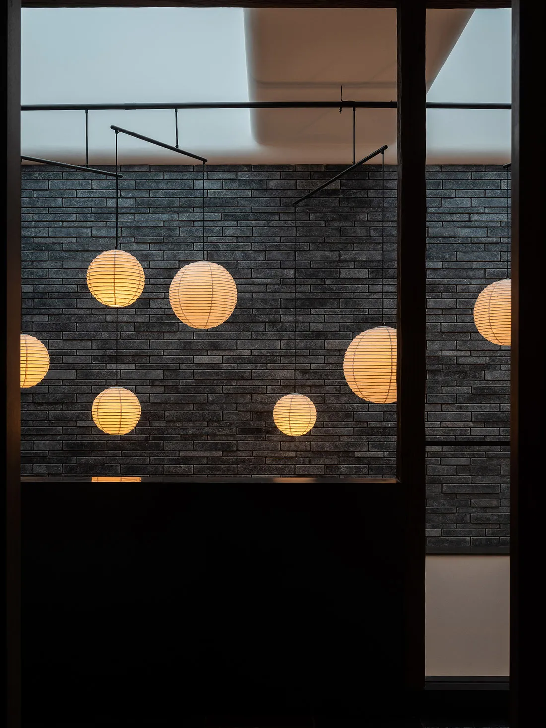 Paper lanterns hanging from a brick wall