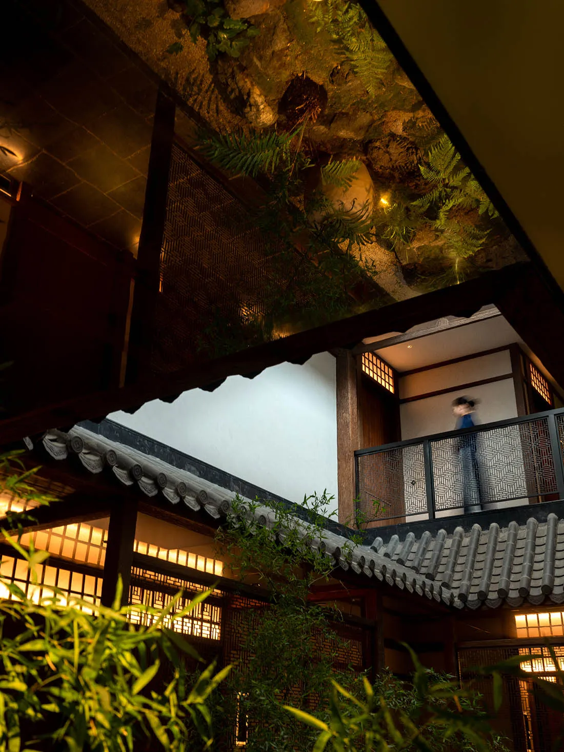 傳統日式住宅室內,搭配溫暖燈光、木樑與竹子植物。