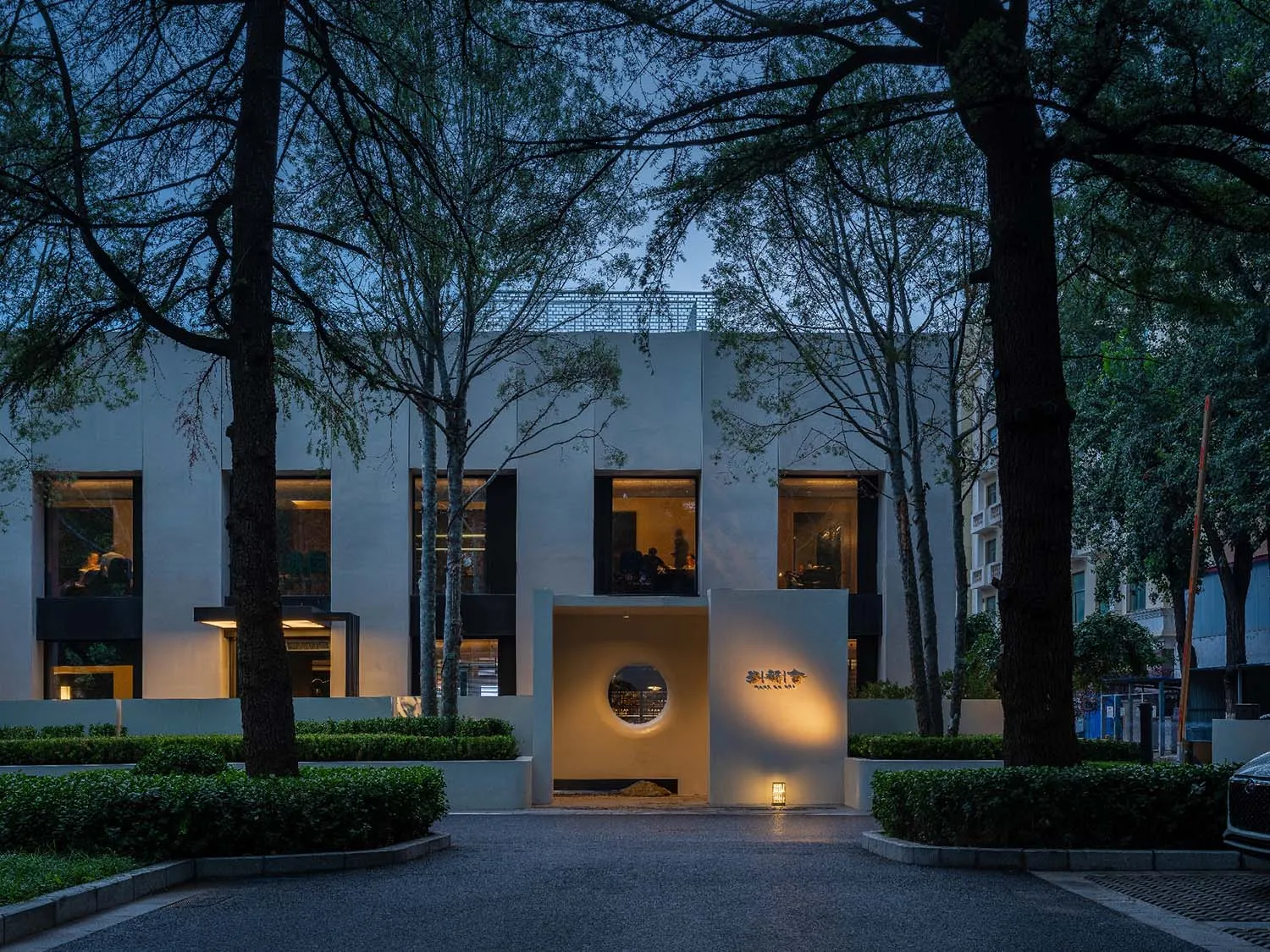 Modern restaurant with glass windows and concrete walls.