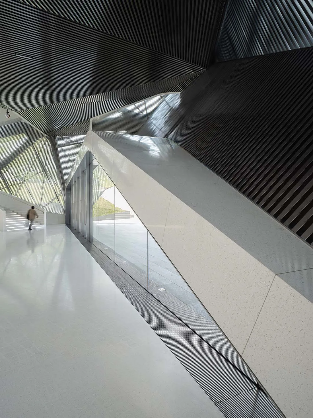 Modern interior design featuring glass, concrete, and metal materials.