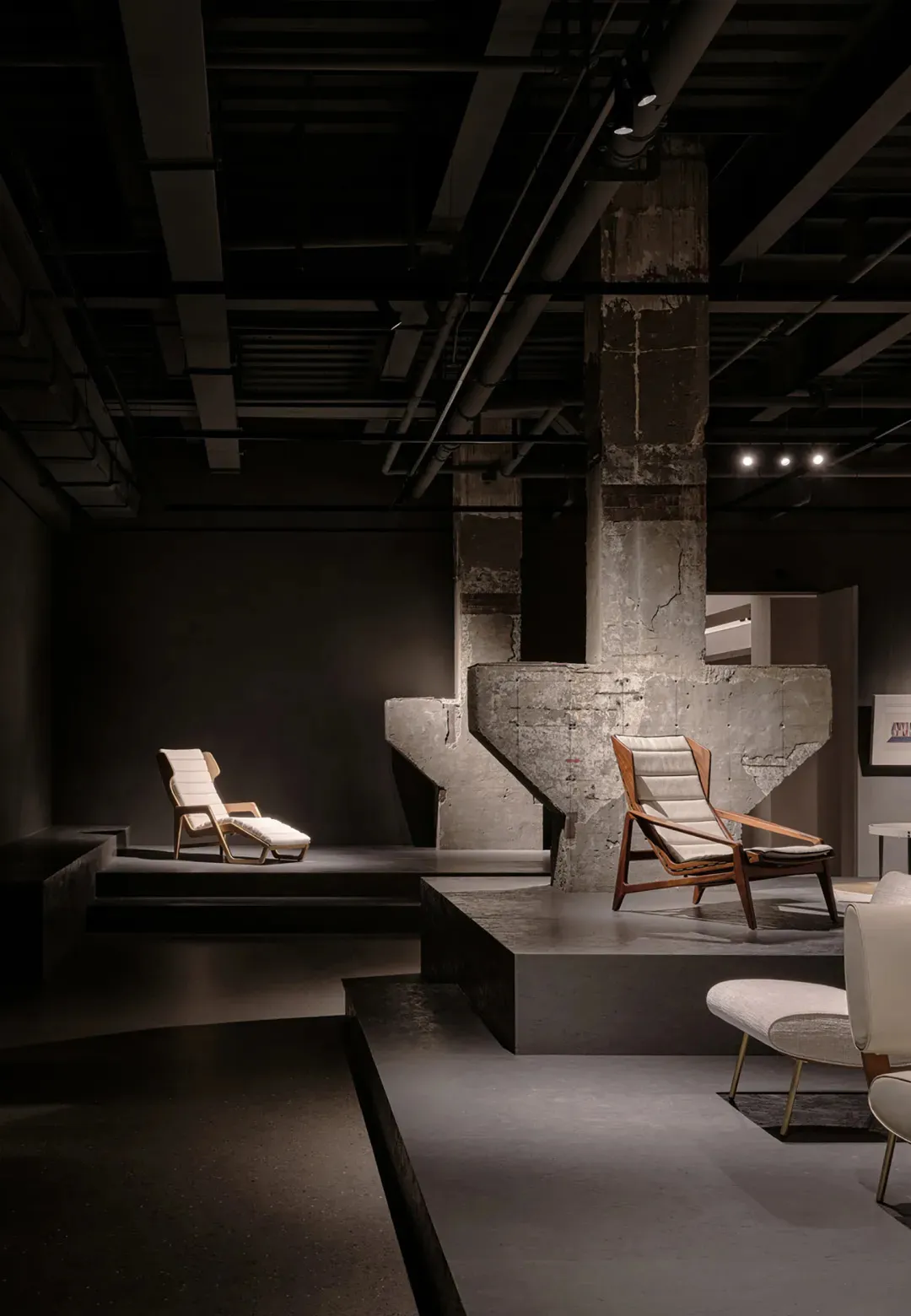 Industrial-style interior featuring a concrete pillar and wooden furniture, showcasing contemporary design elements.