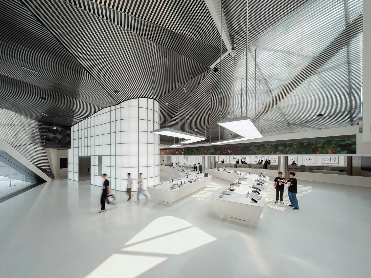 A spacious, white-tiled office with glass walls and metal accents