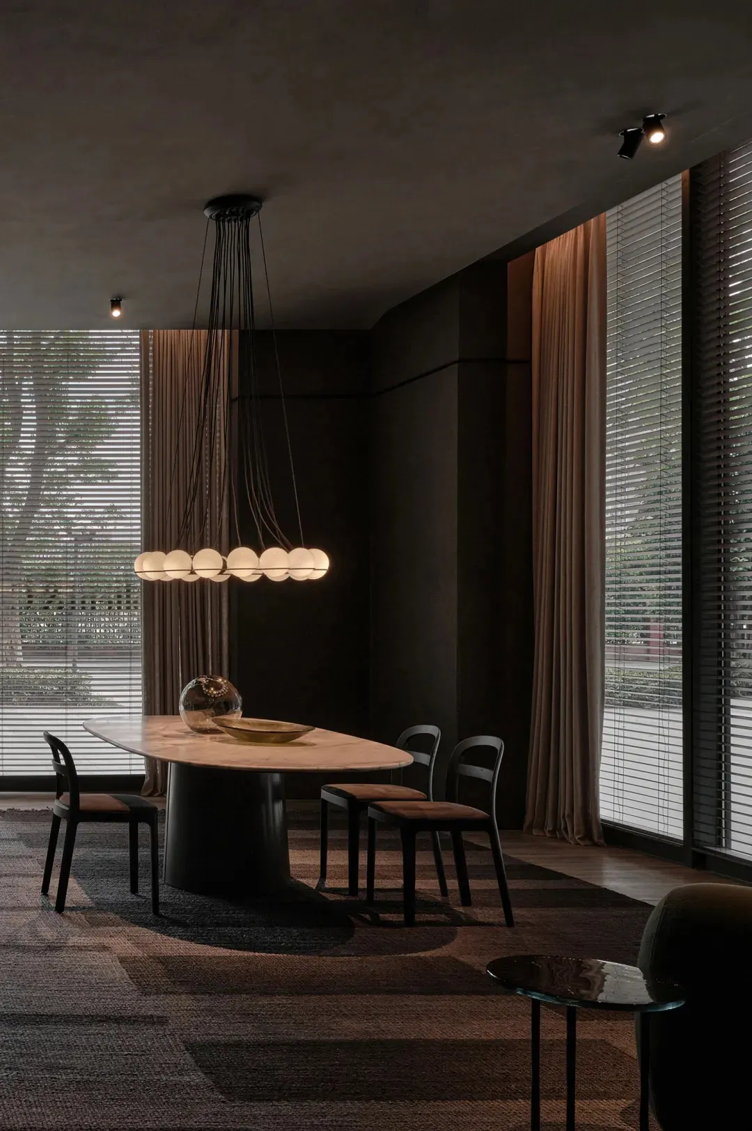 Modern dining room featuring a marble table, black chairs, and a hanging chandelier.