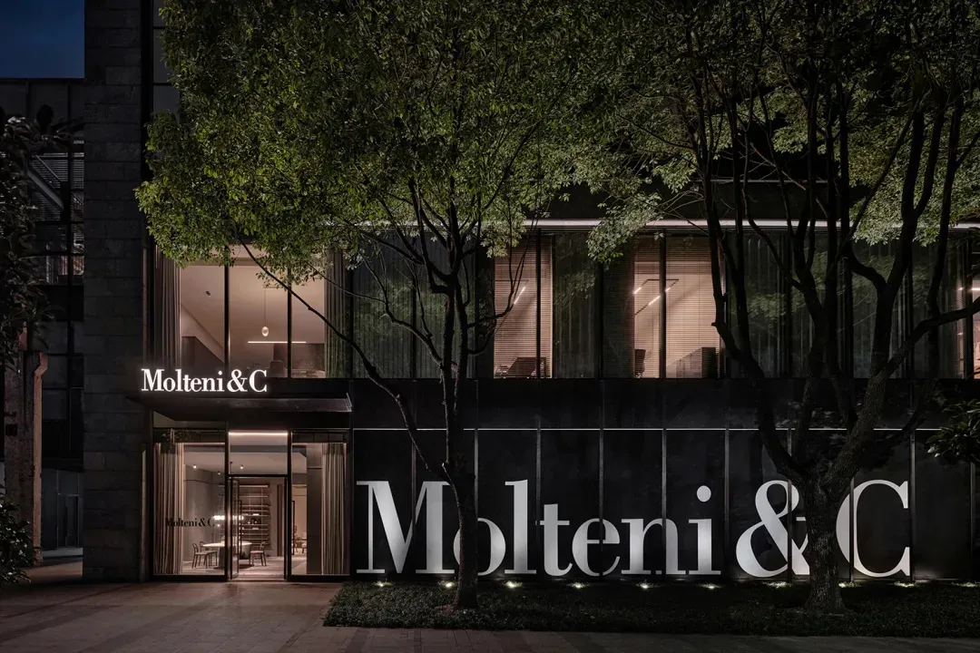 A modern storefront featuring glass windows and black signage.
