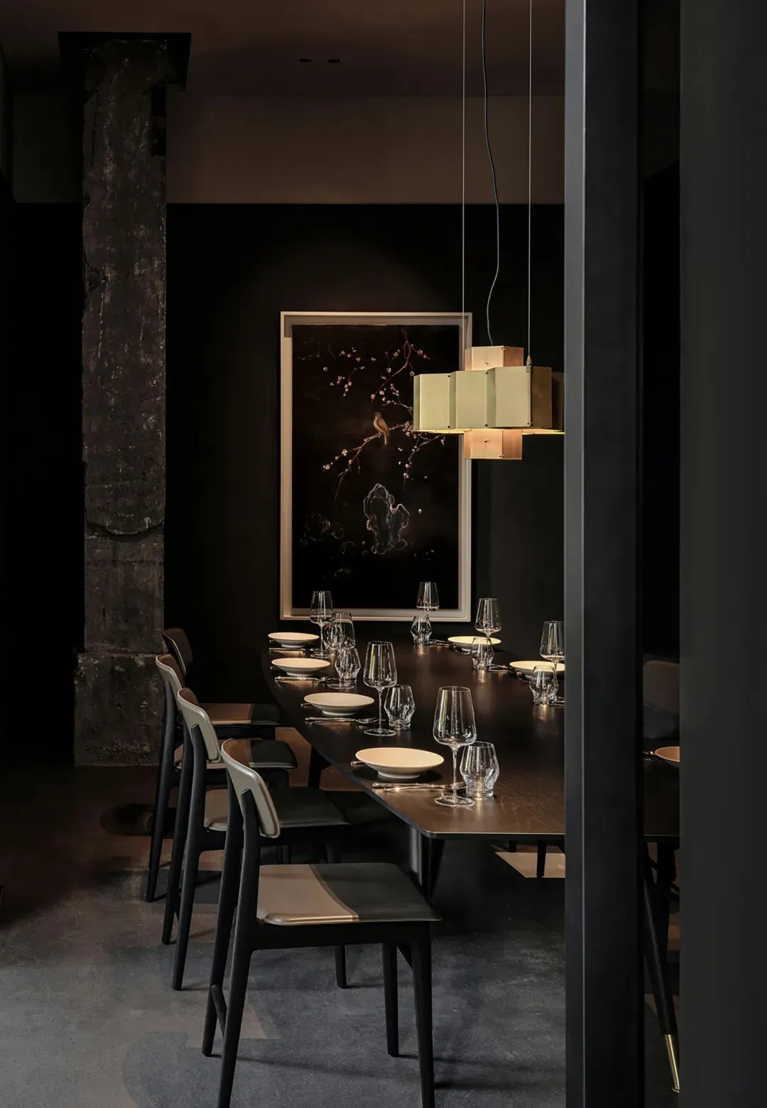 Modern minimalist restaurant interior with black walls, dark wooden tables, and metallic accents.