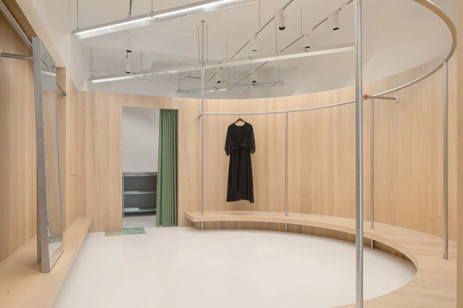 A modern fashion retail store with wooden paneling, featuring a dress hanging on a rail.