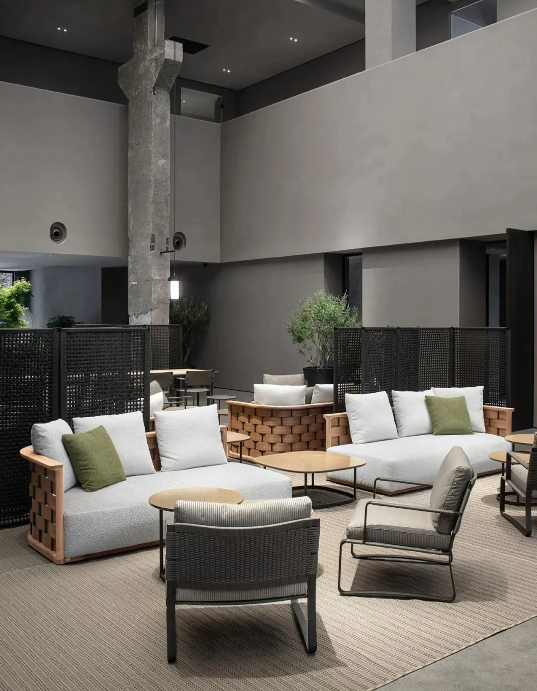 A modern hotel lobby with concrete, wood, and textile elements