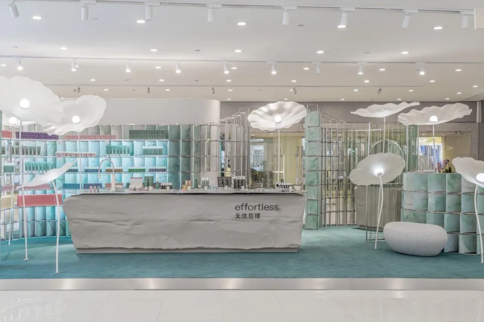 Modern retail storefront with concrete walls, glass displays, and illuminated light fixtures.