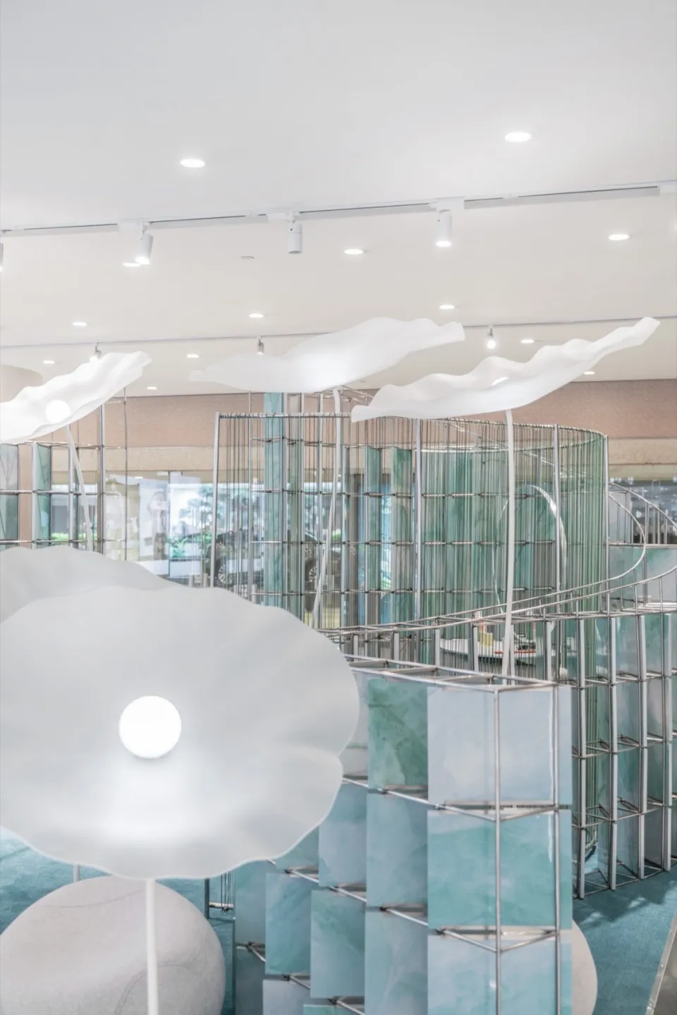 A minimalist retail showroom with transparent glass elements and modern light fixtures.