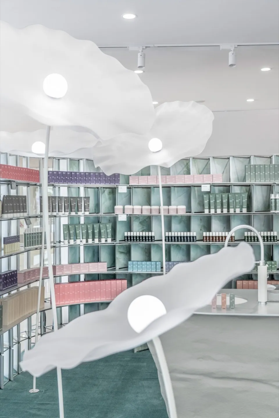 A modern retail space featuring minimalist white interior design with sculptural white flowers.