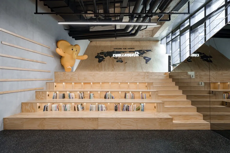 A modern, industrial-style library with wooden shelves and steps.