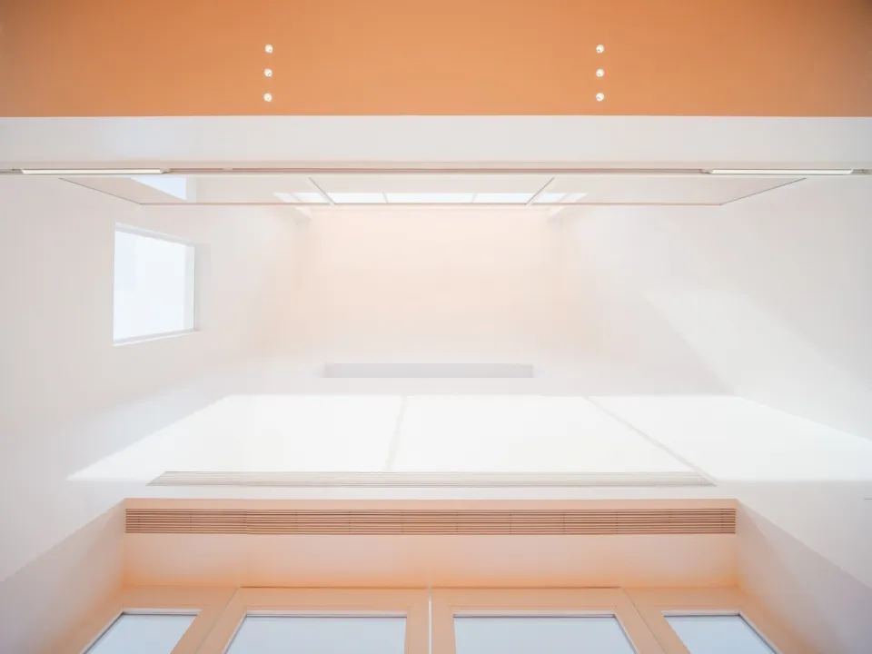 A modern interior space with white concrete walls and floors, white windows, and white ceiling.