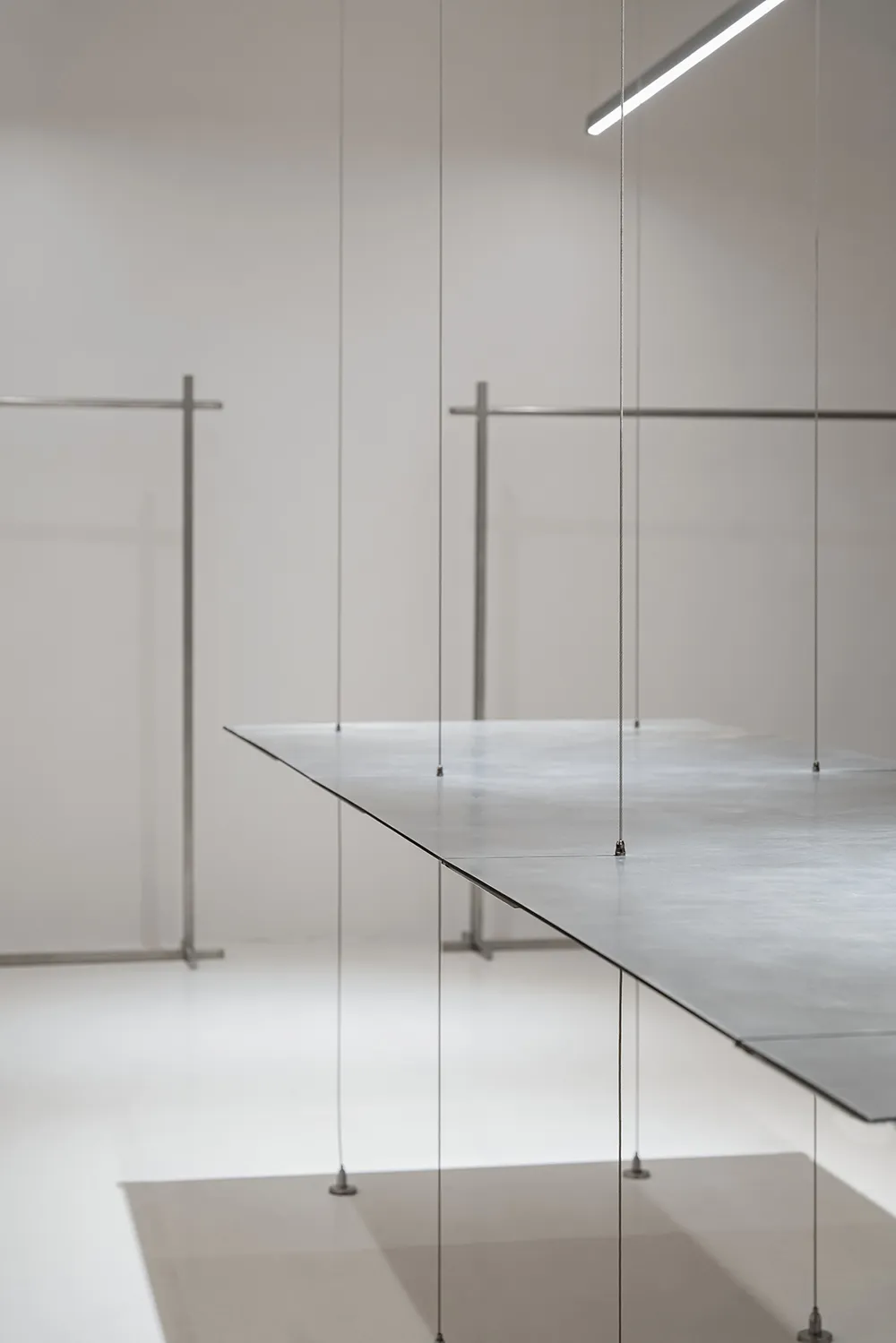 Minimalist metal counter suspended from a white wall in a spacious, open-plan environment.