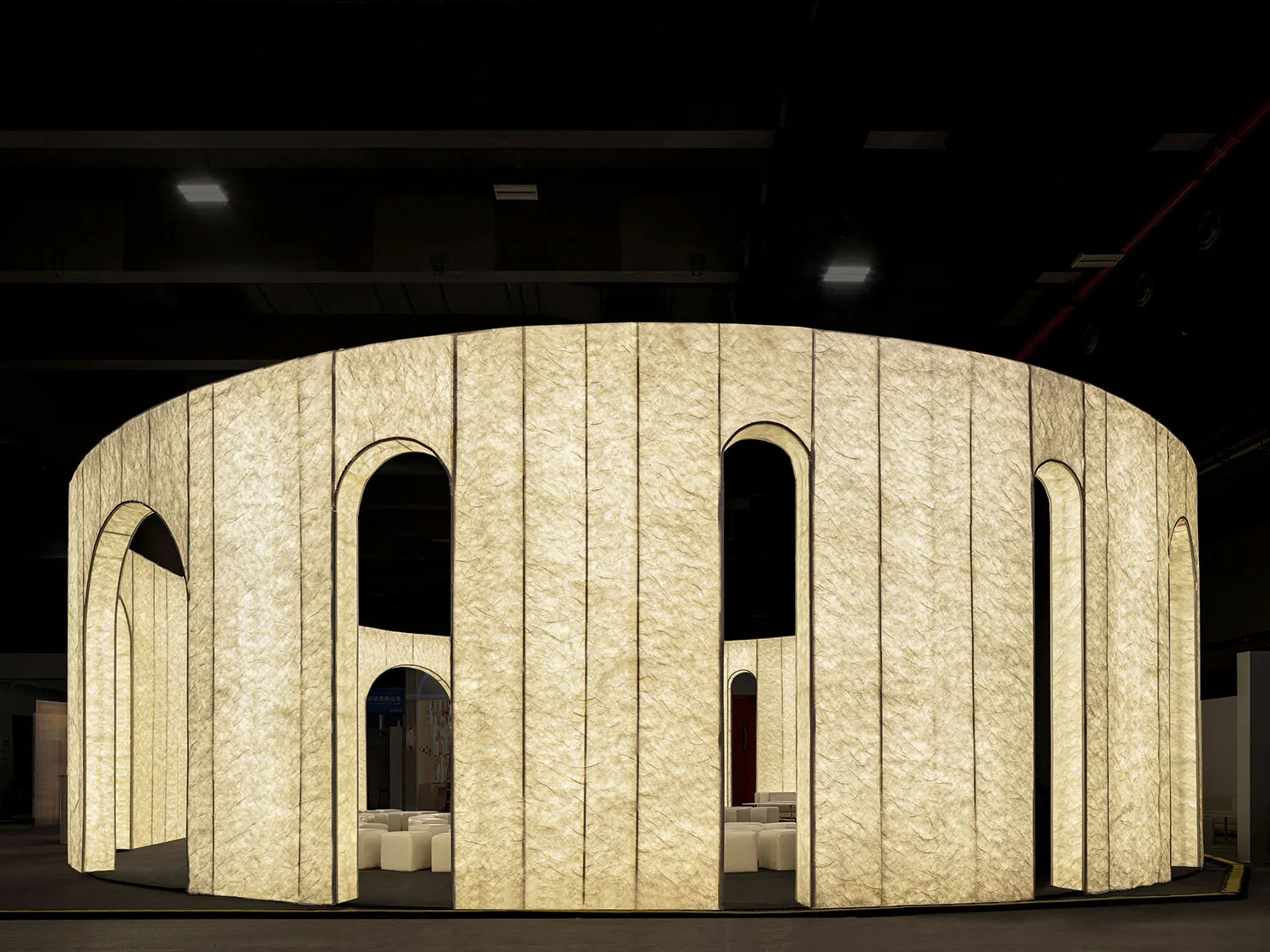 A minimalist architectural installation featuring textured fabric panels.