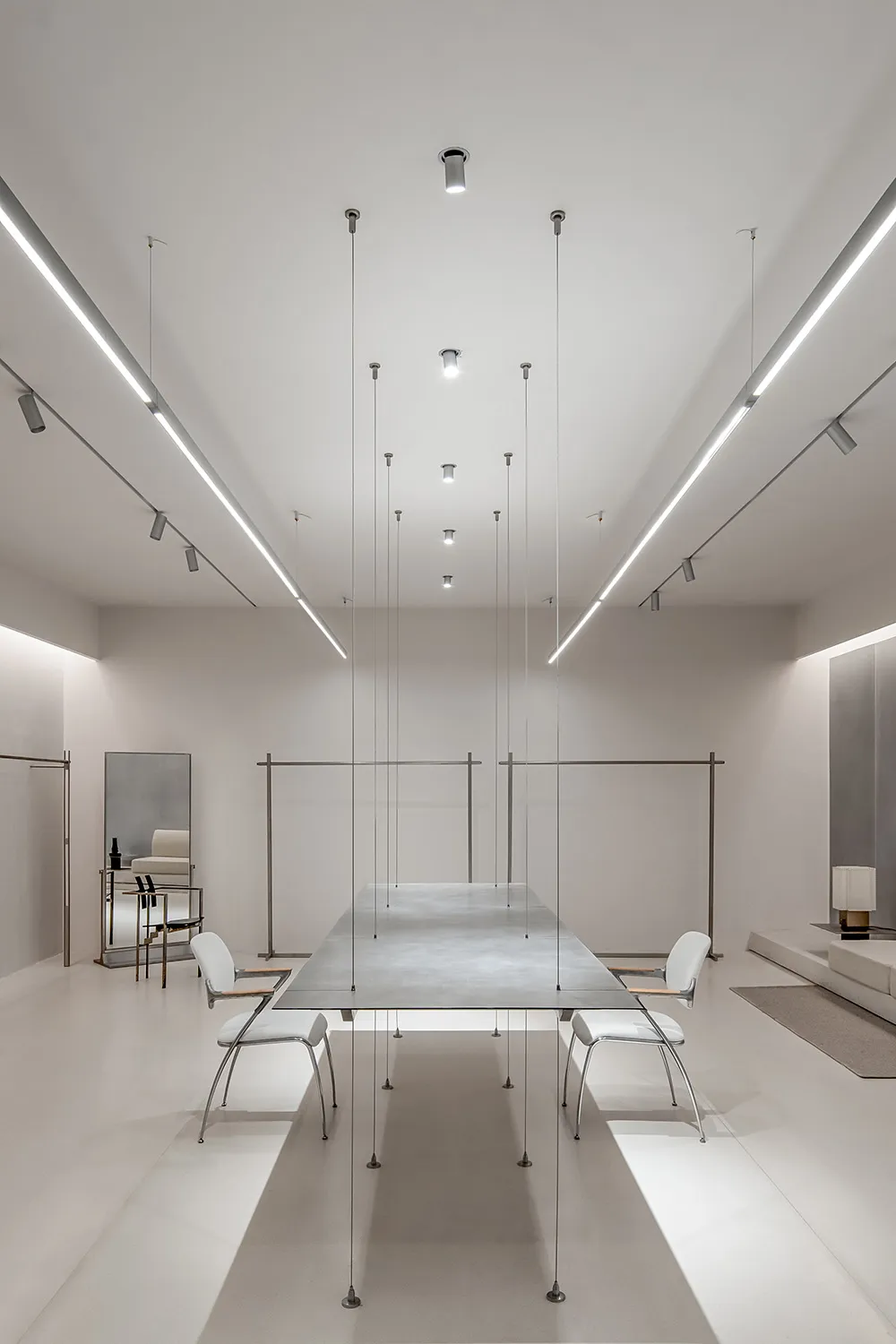 簡約俐落的餐廳室內,拋光混凝土餐區設有長形餐桌與當代