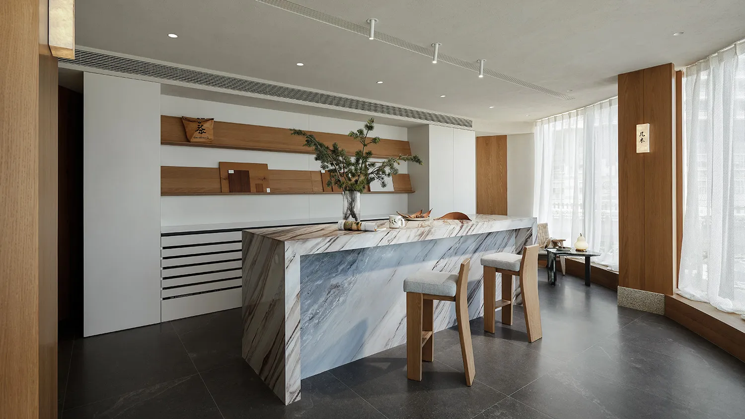 Minimalist kitchen bar area featuring a modern design with marble countertops and wooden stools.