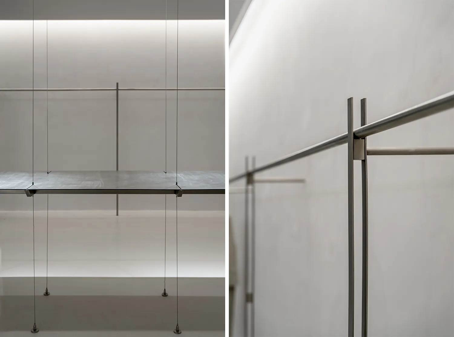 A minimalist metal shelf system supported by thin cables.