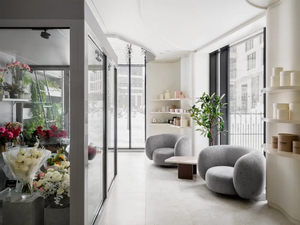 Modern minimalist spa interior with concrete, glass, and wooden materials, featuring comfortable seating and tranquil decor.