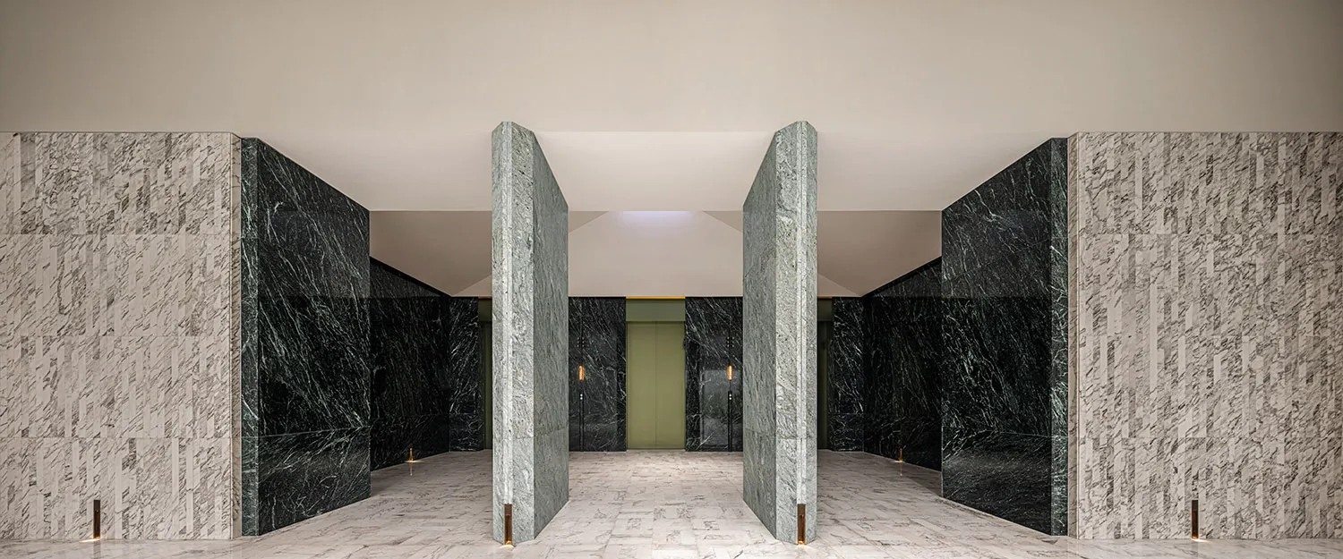 An elegant modern lobby featuring marble walls and flooring.