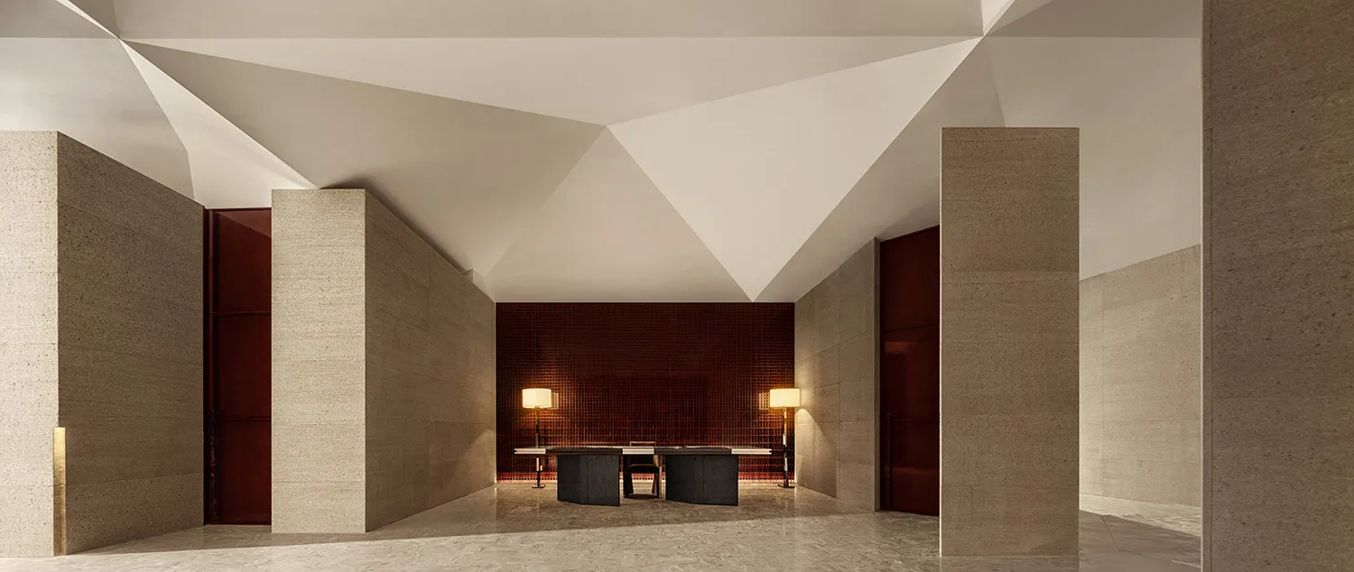 A spacious hotel lobby with minimalist design, concrete walls, and geometric ceiling.